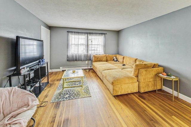 living room with a textured ceiling, hardwood / wood-style flooring, and a baseboard heating unit