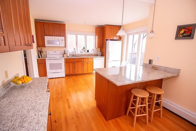 175 Winthrop Rd Unit 3, Brookline, MA 02445 - kitchen featuring white appliances, light wood-style flooring, a peninsula, and brown cabinets