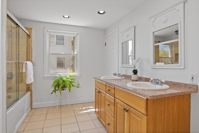 bathroom with shower / bath combination with glass door, double vanity, a sink, and tile patterned flooring