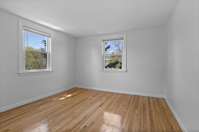 unfurnished room with baseboards and light wood-style flooring