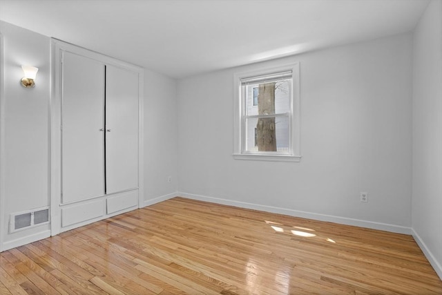 unfurnished room with baseboards, visible vents, and light wood finished floors