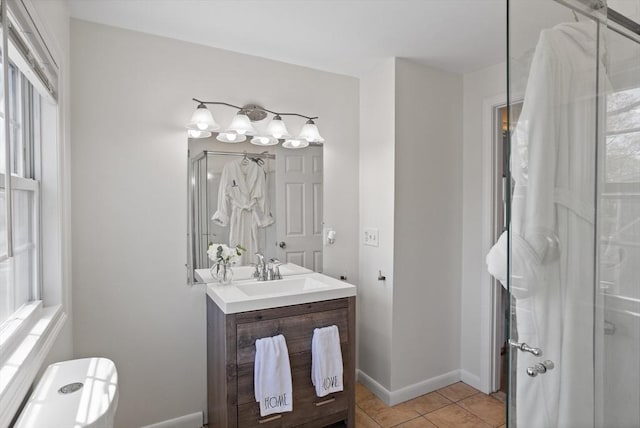 bathroom with tile patterned flooring, baseboards, a stall shower, and vanity