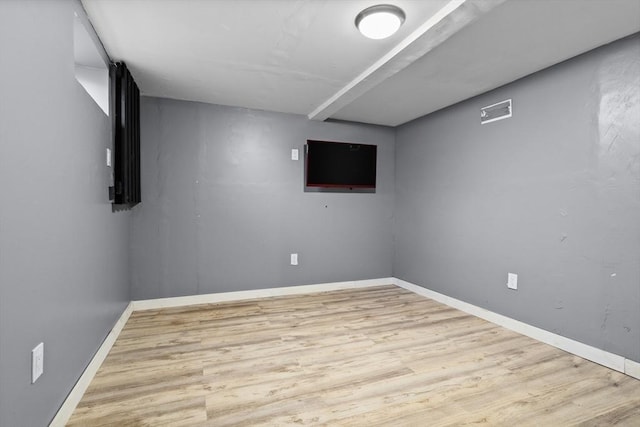 finished below grade area featuring baseboards and wood finished floors
