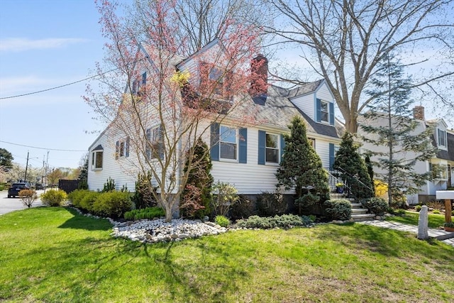 view of side of property featuring a lawn and a chimney