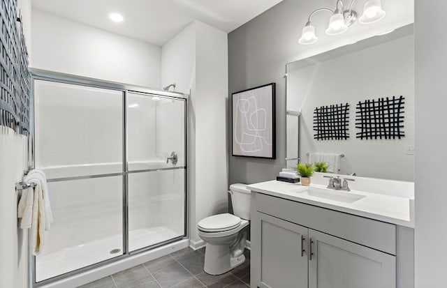 bathroom featuring toilet, vanity, tile patterned floors, and a shower with shower door