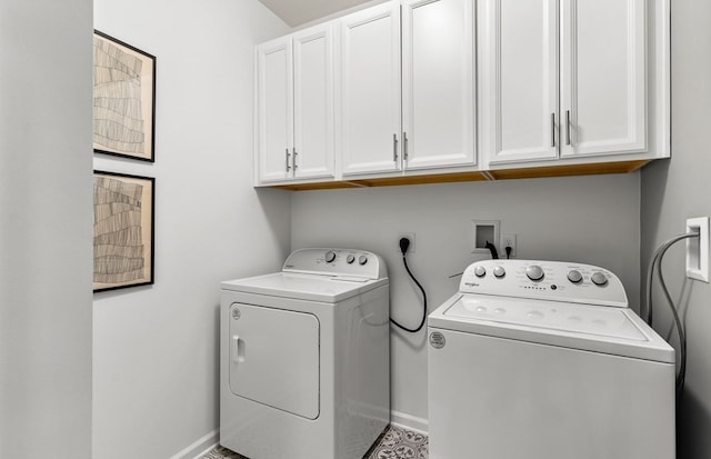 clothes washing area with washer and clothes dryer and cabinets