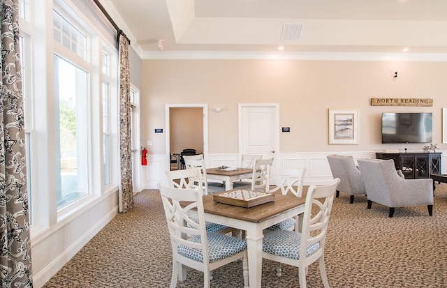 carpeted dining space featuring ornamental molding and a healthy amount of sunlight