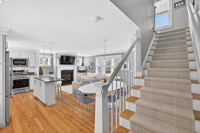 53 W Vine St Unit A, Provincetown, MA 02657 - stairway with wood finished floors, plenty of natural light, a glass covered fireplace, and recessed lighting