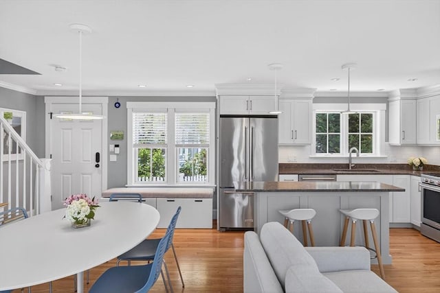 53 W Vine St Unit A, Provincetown, MA 02657 - kitchen featuring appliances with stainless steel finishes, plenty of natural light, backsplash, white cabinetry, and crown molding