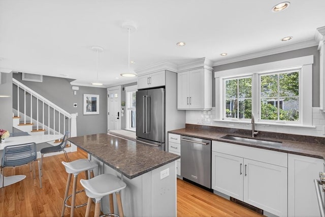 53 W Vine St Unit A, Provincetown, MA 02657 - kitchen featuring appliances with stainless steel finishes, tasteful backsplash, white cabinets, light wood finished floors, and recessed lighting
