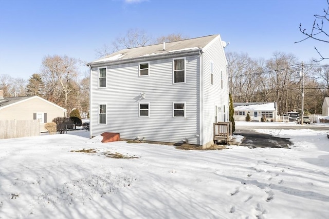 view of snow covered rear of property