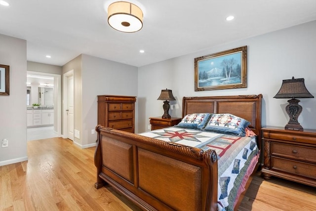 bedroom with light wood-type flooring and connected bathroom