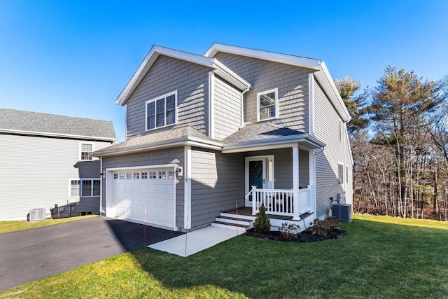 view of property with cooling unit, a garage, and a front yard