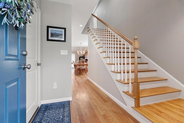 foyer entrance with a chandelier and light hardwood / wood-style floors