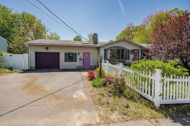 ranch-style house with a garage, a chimney, fence, and asphalt driveway