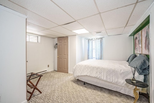 bedroom with a drop ceiling, baseboards, and carpet floors
