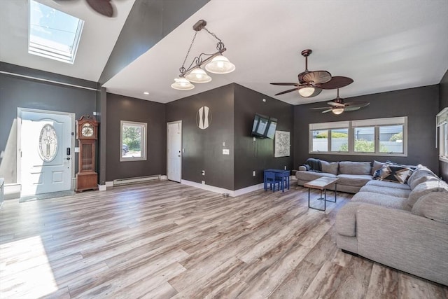 living area with light wood-type flooring, a ceiling fan, healthy amount of natural light, and vaulted ceiling