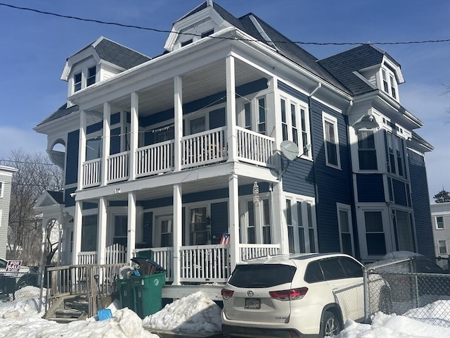 exterior space featuring covered porch and fence