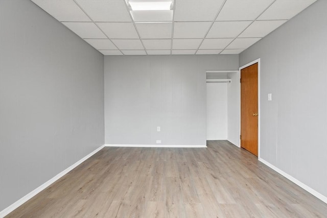 309 E Eagle St, Boston, MA 02128 - unfurnished bedroom with wood finished floors, a paneled ceiling, a closet, and baseboards