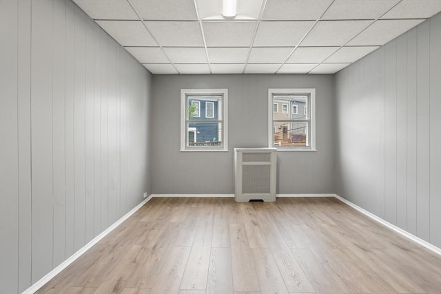 309 E Eagle St, Boston, MA 02128 - unfurnished room with wood finished floors, radiator heating unit, a drop ceiling, baseboards, and wood walls