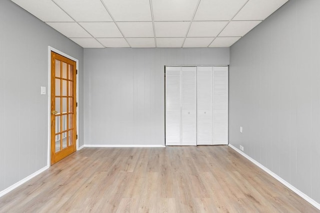 309 E Eagle St, Boston, MA 02128 - unfurnished bedroom with light wood-style flooring, a paneled ceiling, baseboards, and a closet