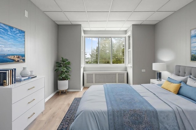 309 E Eagle St, Boston, MA 02128 - bedroom with radiator heating unit, light wood finished floors, and a drop ceiling