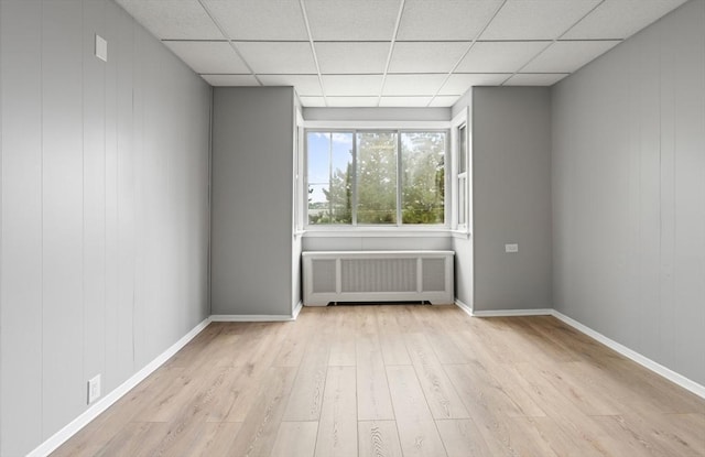 309 E Eagle St, Boston, MA 02128 - empty room with radiator, wood finished floors, a paneled ceiling, and baseboards