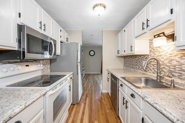 47 Patrick Rd Unit 47, Tewksbury, MA 01876 - kitchen featuring appliances with stainless steel finishes, a sink, baseboards, and white cabinetry