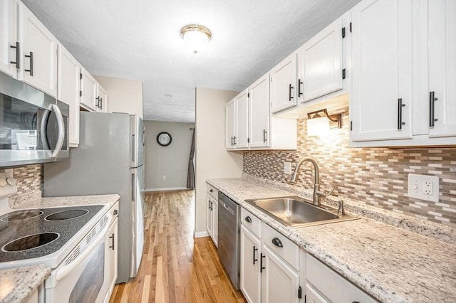 47 Patrick Rd Unit 47, Tewksbury, MA 01876 - kitchen featuring appliances with stainless steel finishes, a sink, baseboards, and white cabinetry