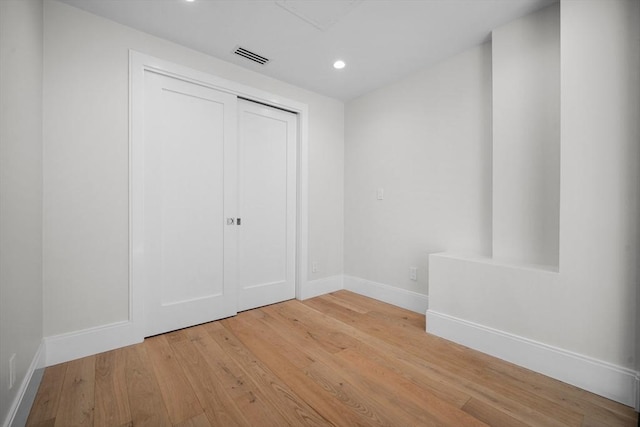 unfurnished bedroom with light wood-type flooring and a closet