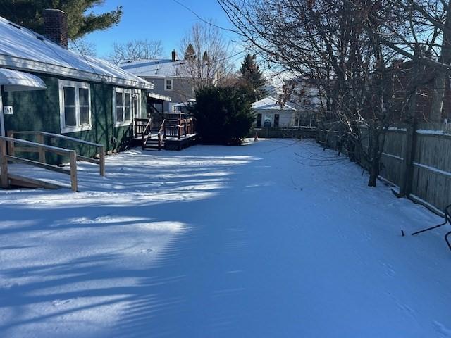 yard layered in snow with a wooden deck