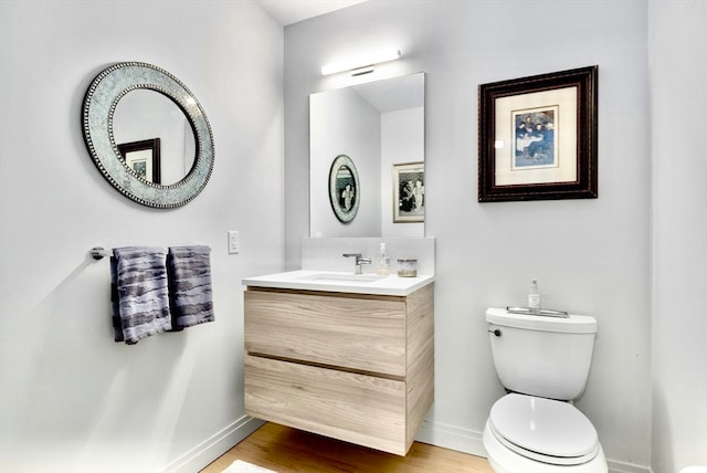 bathroom with hardwood / wood-style floors, vanity, and toilet