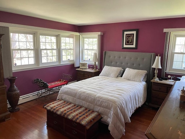 bedroom with baseboard heating and dark wood-style flooring