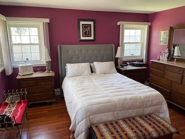 bedroom with dark wood-type flooring and a baseboard radiator