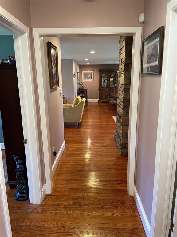 hallway with recessed lighting, wood finished floors, and baseboards