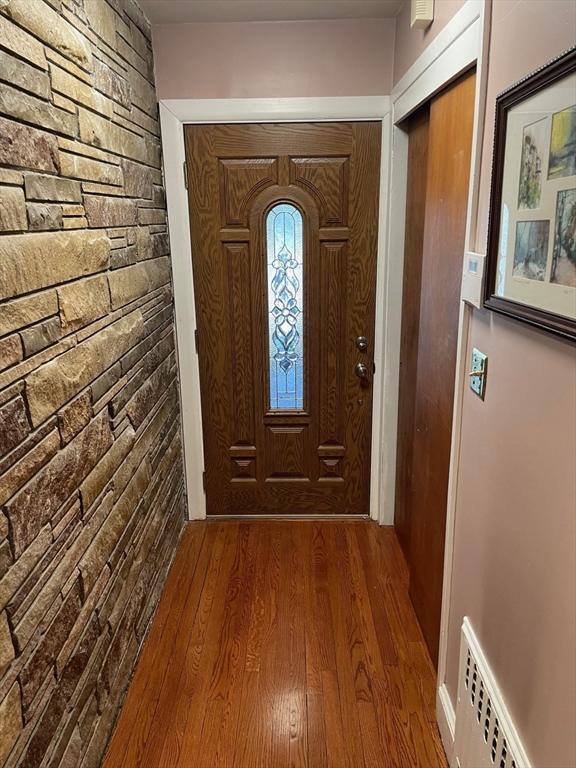 doorway to outside featuring visible vents and dark wood-style flooring