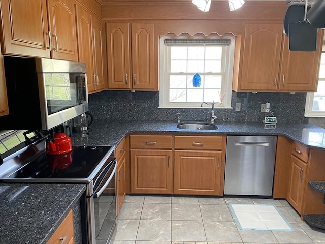 kitchen with tasteful backsplash, brown cabinetry, stainless steel appliances, and a sink