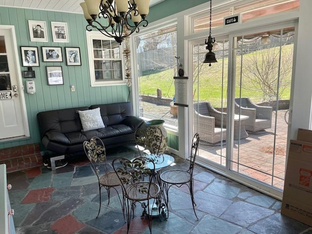 sunroom / solarium featuring an inviting chandelier