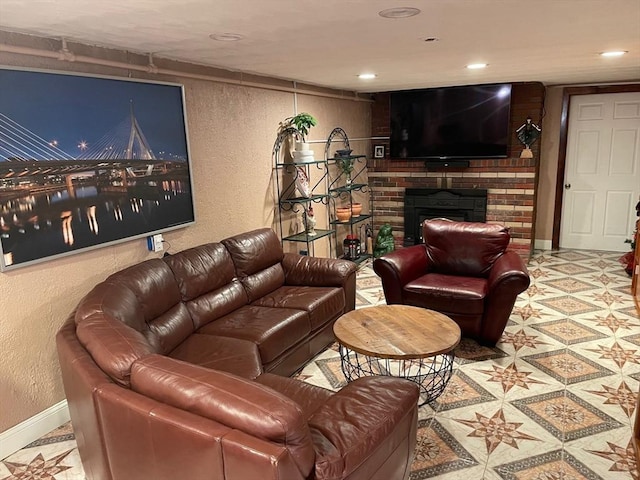 living room featuring a textured wall, a brick fireplace, baseboards, and tile patterned floors