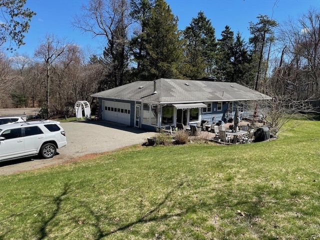 view of front of house with a front lawn, driveway, and a garage