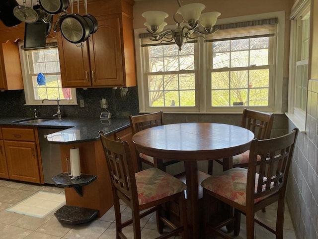 dining room with light tile patterned flooring, plenty of natural light, and an inviting chandelier