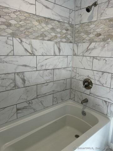 bathroom with tiled shower / bath combo