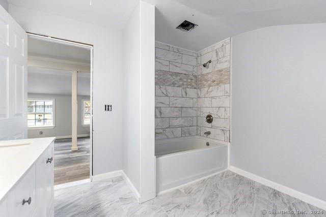 bathroom with tiled shower / bath and vanity