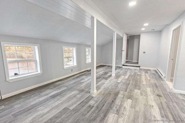 interior space with hardwood / wood-style flooring, a wealth of natural light, and a baseboard heating unit