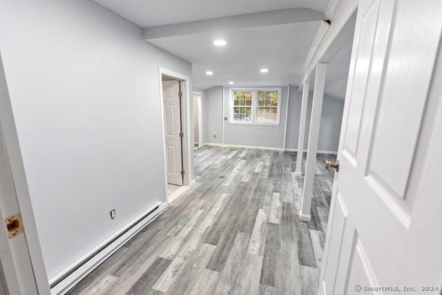 hall with a baseboard radiator and light hardwood / wood-style flooring