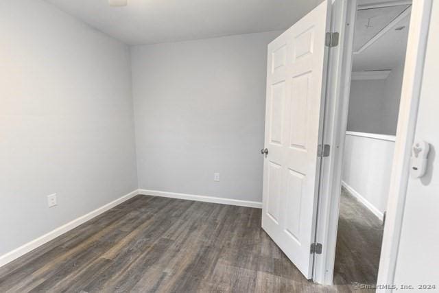 unfurnished room with dark hardwood / wood-style flooring