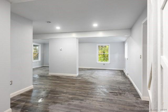 empty room with a healthy amount of sunlight and dark wood-type flooring