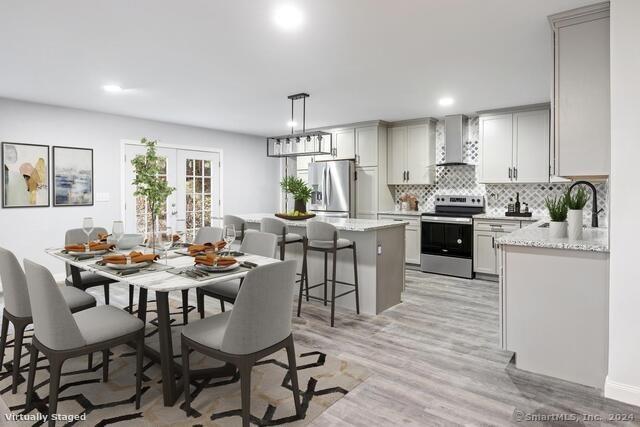 dining area featuring light wood-type flooring, french doors, and sink