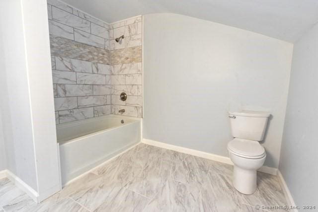 bathroom featuring toilet and tiled shower / bath combo