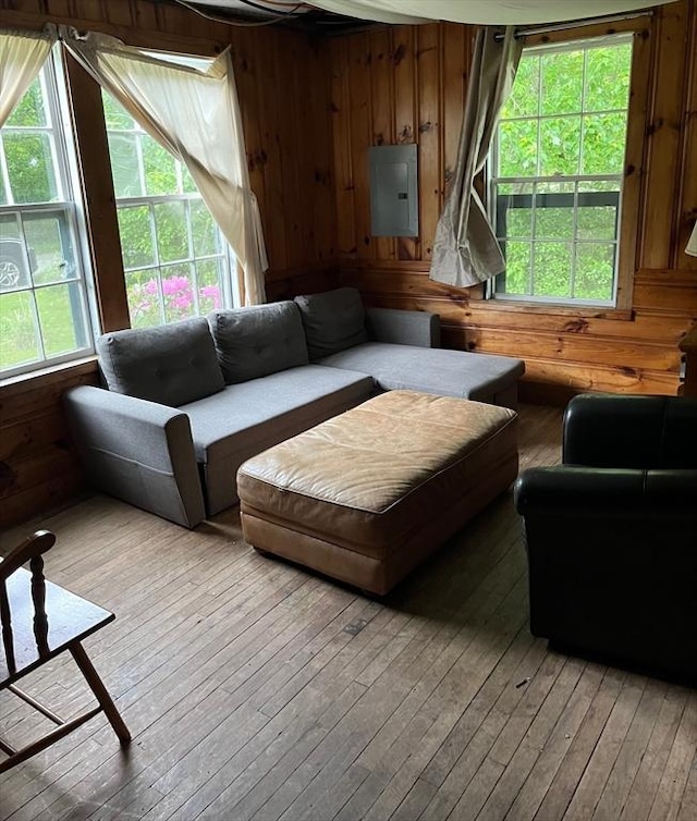 living room featuring wooden walls, light wood-type flooring, and electric panel